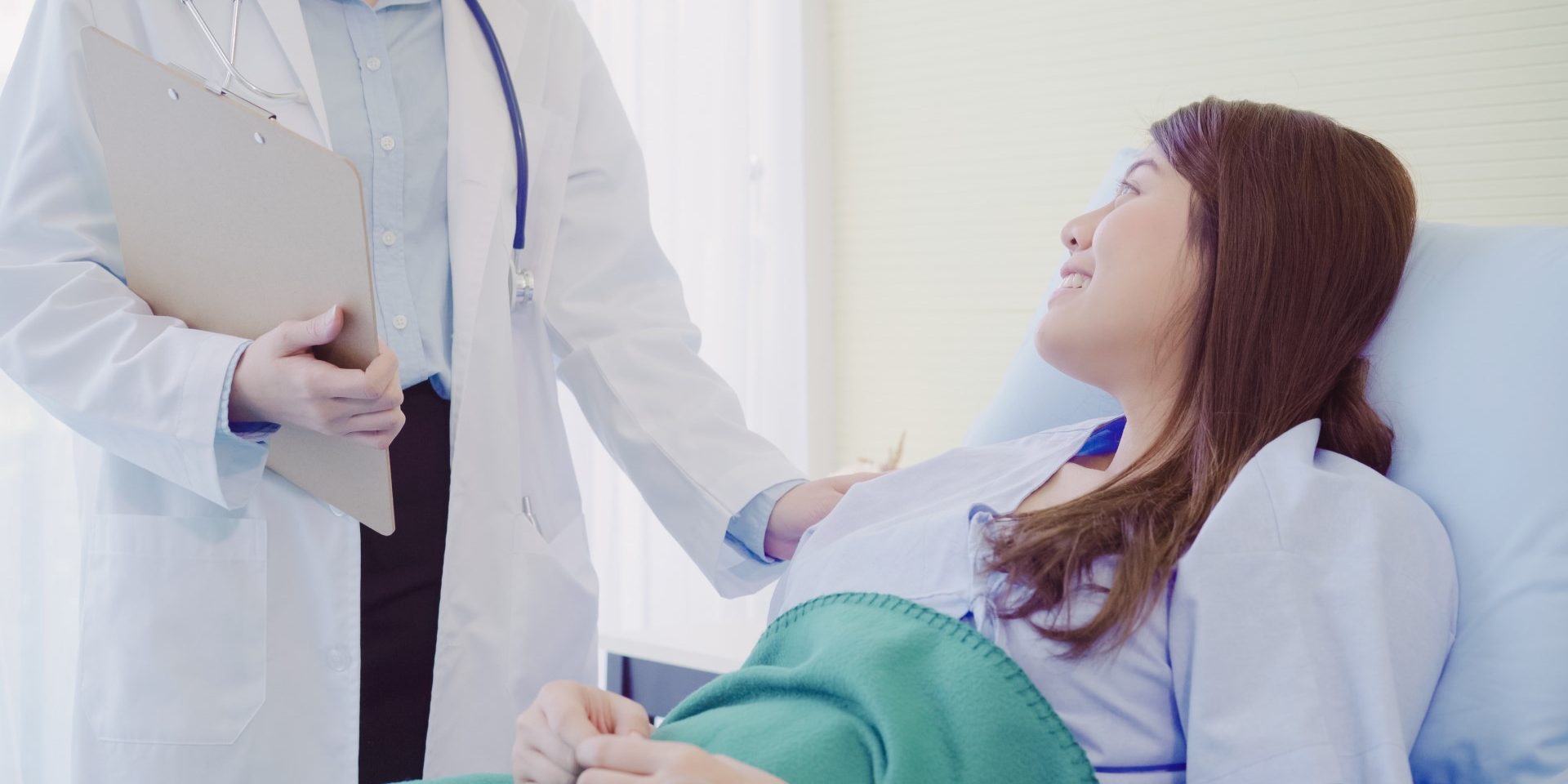 Beautiful smart Asian doctor and patient discussing and explaini